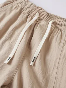 Close-up of men's cotton-linen pants showing the elastic waist and white drawstring