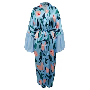 Détail de la robe satinée bleu clair avec motif floral rose et feuilles vertes.