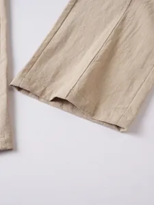Close-up detail of breathable cotton linen fabric and hem on men's casual beach trousers.