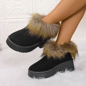 Primer plano detallado de botas de nieve con plataforma negras y ribete de piel sintética