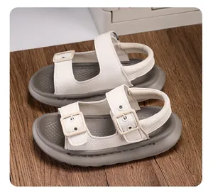 Detail view of children's white leather-textured sandals with double buckle straps