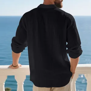 Back view of a stylish man wearing a black loose linen long-sleeved polo shirt by the sea