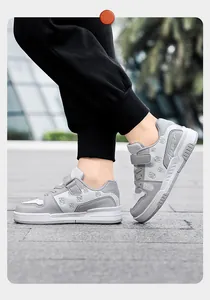 Detaillierte Seitenansicht grauer Kinder-Sneaker mit Klettverschluss und Mustern