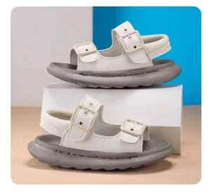 Detailed side view of children's white pebbled leather sandals with grey soft soles.