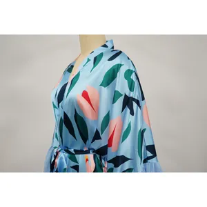 Détail de la tunique de plage bleue à imprimé floral en tissu satiné élégant et doux