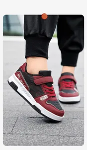 Detailansicht der stylischen rot-schwarzen Kinder-Sportsneaker auf dem Gehweg