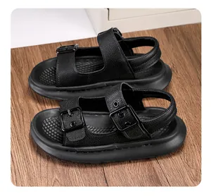 Close-up of black children's sandals with double buckle straps on a wooden surface