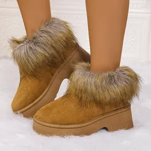 Primer plano de botas de nieve de ante marrón con suelas gruesas y pelo sintético