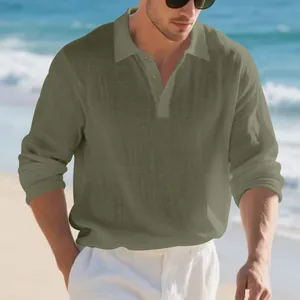 Casual men's long sleeve linen polo shirt in olive green shown in a beach setting