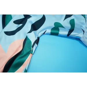 Gros plan sur les finitions de couture d'un cardigan de plage en satin bleu à fleurs