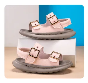 Side view of pink children's sandals with soft soles and golden buckles.