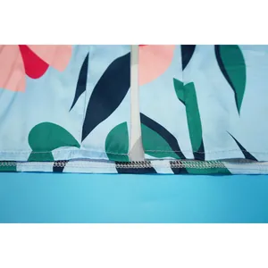 Détail de couture de l'ourlet sur un gilet de plage léger à imprimé floral.