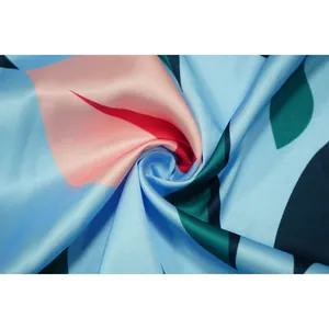 Vue macro d'un tissu imprimé floral soyeux et doux montrant un drapé élégant pour robe de plage
