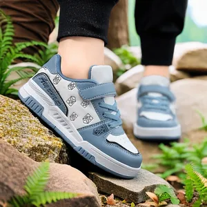 Stylische blau-weiße Jungen-Sneaker mit Klettverschluss in einer Parkumgebung