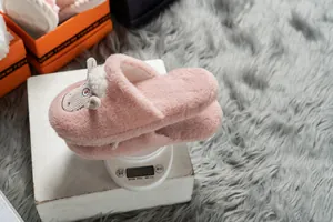 Leichte rosa Plüsch-Hausschuhe für Damen, Gewicht 138,4 g auf einer weißen Waage.