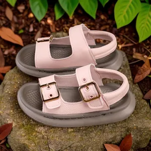 Pink children's open-toe sandals with soft grey soles and gold buckles