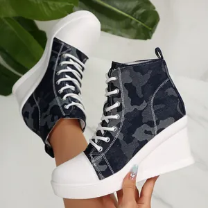 Close-up detail of women's camouflage high-top wedge sneakers with white thick platform