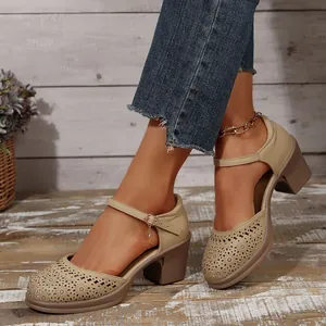 Close-up detail of stylish beige Mary Jane pumps featuring elegant laser-cut floral patterns