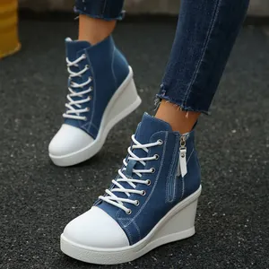 Detailed view of women's blue denim high-top wedge sneakers with white laces