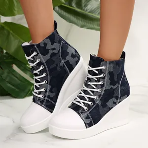Detail view of women's camouflage wedge high-top canvas sneakers shown on foot