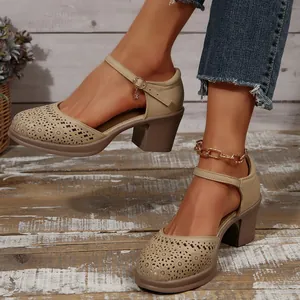 Detail showing beige Mary Jane pumps with hollow floral patterns and chunky heels.