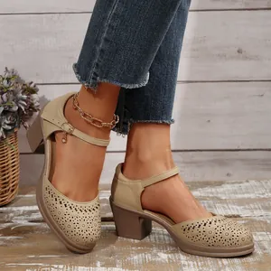 Detail view of beige block-heel shoes with delicate laser-cut floral patterns and ankle strap