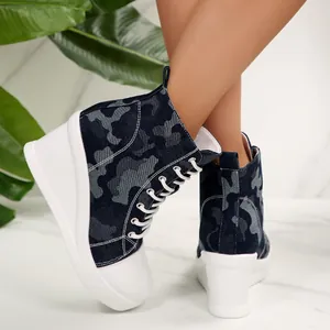 Close-up of stylish camouflage high-top wedge canvas shoes with white platform soles.