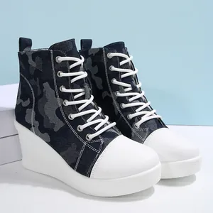 Side view of high-top wedge sneakers with blue camouflage denim and white platform