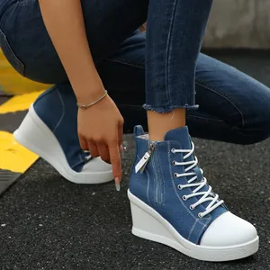 Detailed close-up of blue denim high-top wedge sneakers featuring white laces and side zipper