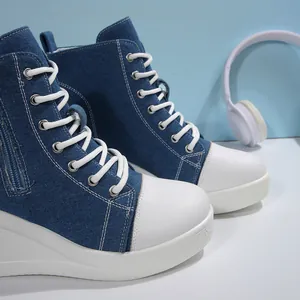 Close-up detail of women's denim high-top platform wedge sneakers with white laces