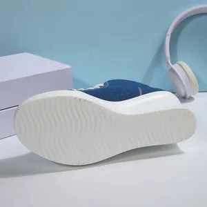 Detailed view of the non-slip platform sole on blue denim high-top canvas sneakers