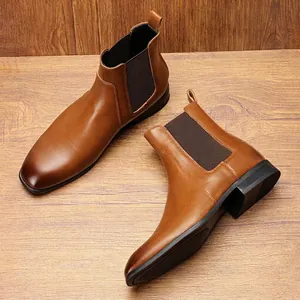 Stivali Chelsea classici in pelle marrone da uomo con un elegante design slip-on su legno