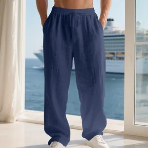 Detail of navy blue men's loose linen-style drawstring pants in a resort balcony setting
