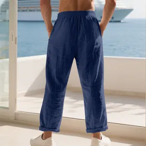 Men's loose navy blue linen trousers shown from behind on a luxury cruise balcony