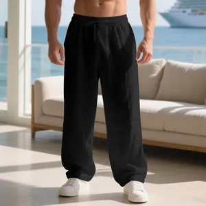 Men's loose black linen trousers with drawstring waist in casual resort setting