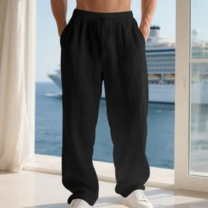 Detail view of men's loose black linen trousers with drawstring waist and breathable fabric