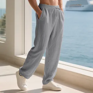Close-up of men's loose grey linen trousers with drawstring waist at seaside resort