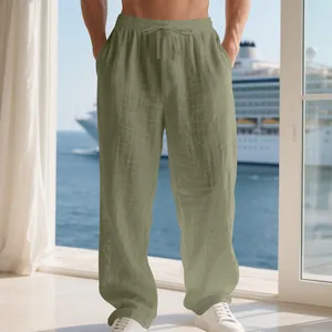 Close-up of men's loose olive green linen trousers with drawstring waist and pocket details