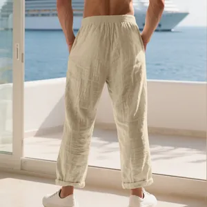 Rear view showing the relaxed fit and texture of men's beige linen trousers outdoors