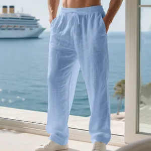 Detail view of men's loose light blue linen pants with drawstring for beach vacation