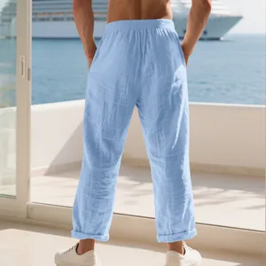 Back view of light blue men's loose linen pants with elastic waist for resort wear