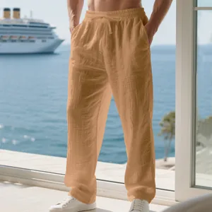 Close-up of men's apricot loose linen trousers with drawstring waist on a sea balcony