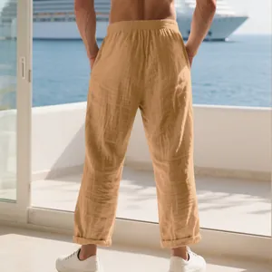 Back view of men's loose khaki linen casual pants in a seaside resort setting