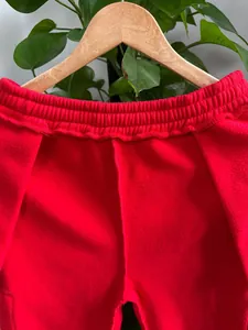 Detailaufnahme der roten Fleece-Jogginghose für Herren mit elastischem Bund und weicher Textur.