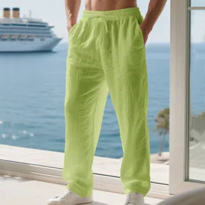 Close-up of men's lime green linen casual trousers on model with a scenic sea view