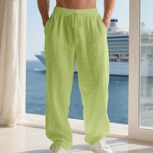Close-up of lime green men's loose linen trousers with drawstring waist on balcony