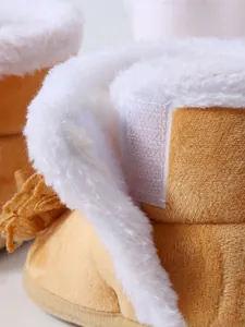 Nahaufnahme von Baby-Winterstiefeln mit weißem Kunstfellfutter und Klettverschluss