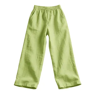 Detail of light green casual pants showing soft crinkle muslin cotton fabric texture