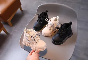 Detailed view of children's Martin boots in black and white textured leather