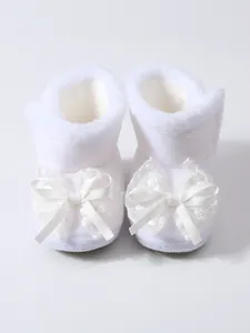 Detailansicht weißer, fleecegefütterter Baby-Lauflernschuhe mit dekorativen Spitzenschleifen